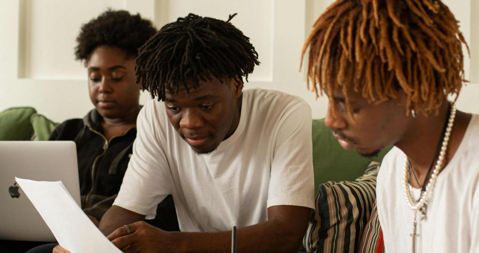 Three Black students doing homework together.