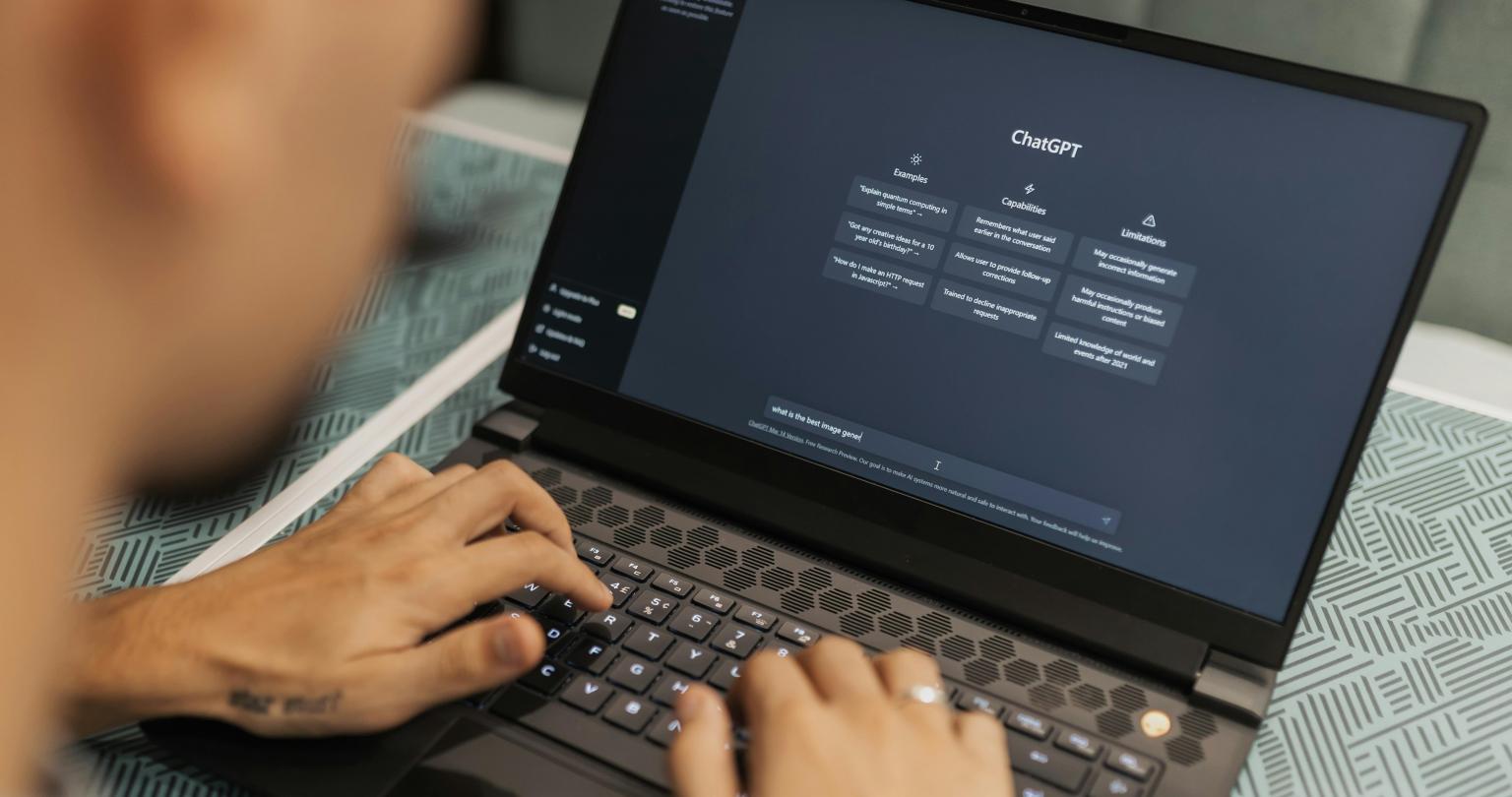 Person typing on the computer with Chat GPT on the screen.